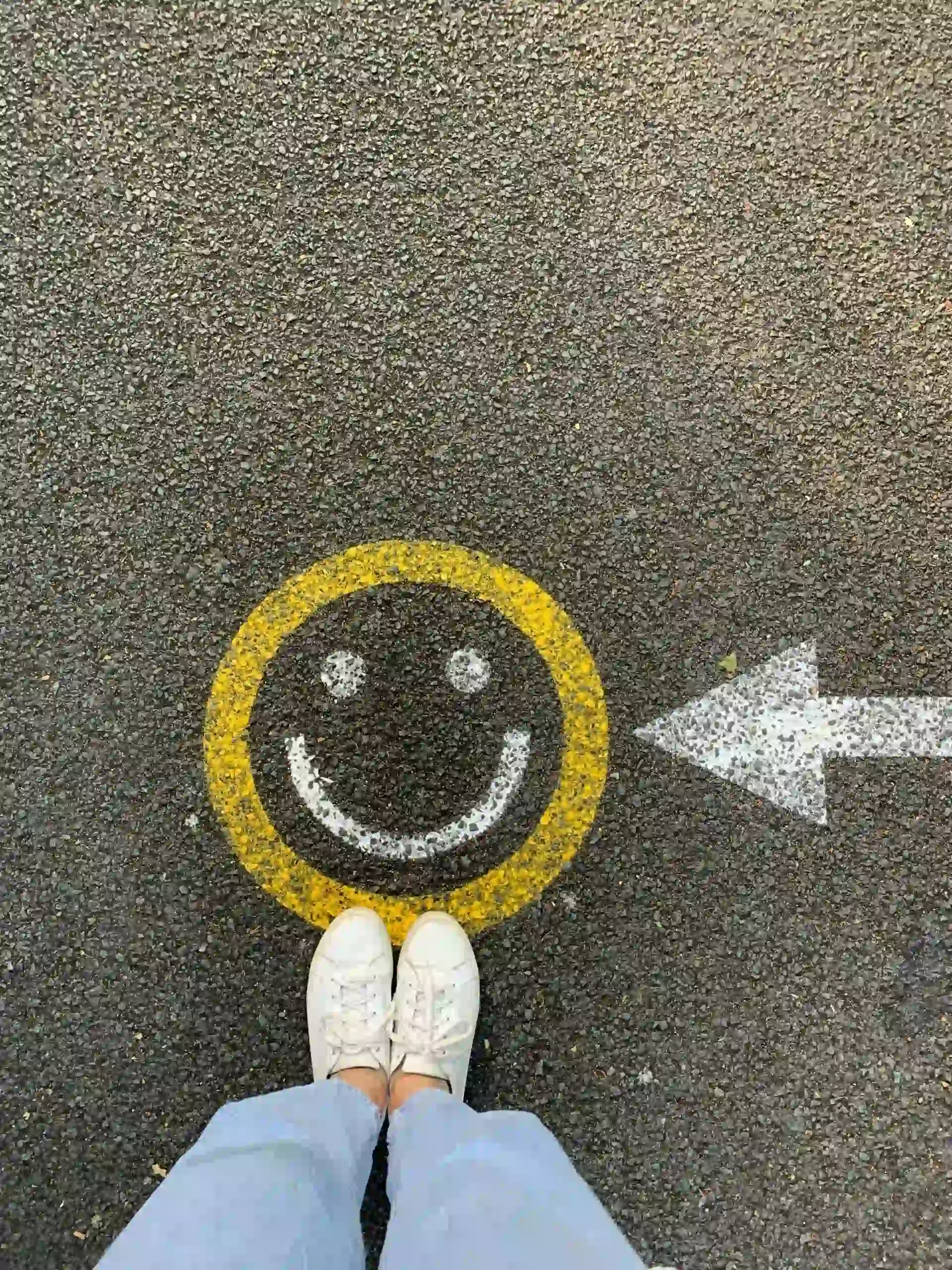 Pieds vus de haut avec un smiley souriant dessiné à la craie